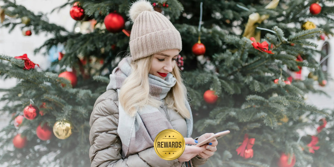 Woman with AloOui rewards on phone and Christmas trees in the background